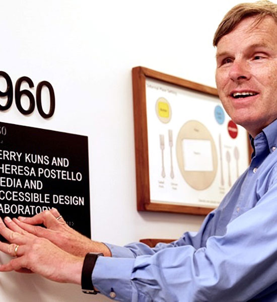 Frank Welte, MAD Lab team mamber, reading the department's room sign by touch